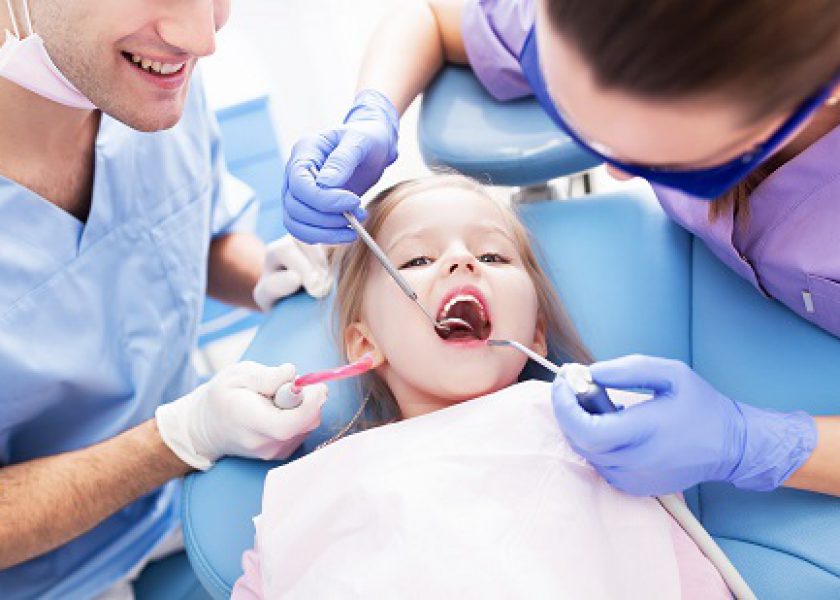 Girl having teeth examined at dentists