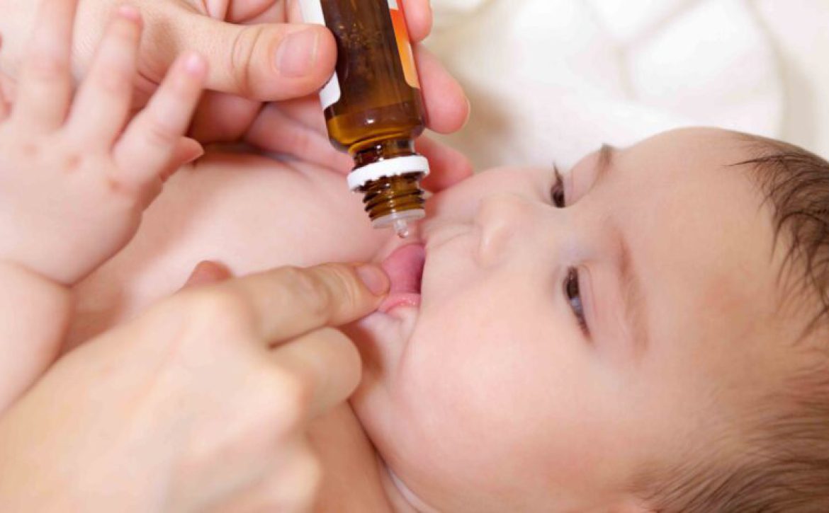 Medical drops oral vaccination to infant for immunisation. Mothe