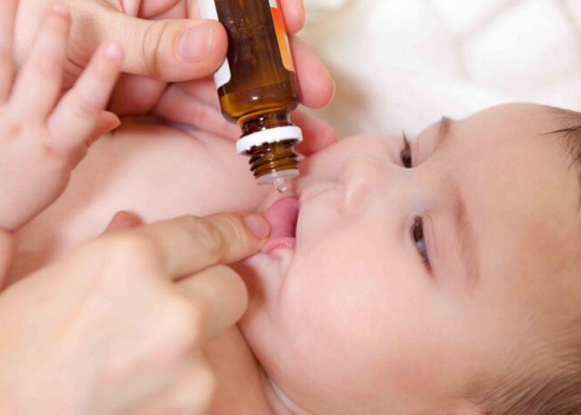 Medical drops oral vaccination to infant for immunisation. Mothe